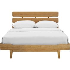 a bed with white pillows and wooden headboard