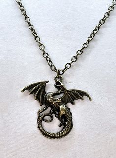 This necklace features a Mythical Dragon that measures 1 3/4"  by 1 3/4". The dragon hangs from 23" of Brass Rolo Chain. Dragon Pendant Necklaces, Brass Dragon, Mythical Dragons, Chain Making, Dragon Necklace, Magical Jewelry, Brass Antique, Dragon Pendant, Rolo Chain