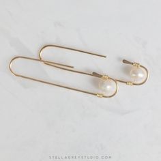 The Zosia earrings are a modern take on the classic pearl earring. Handmade from 18 gauge gold filled wire, these are suitable for sensitive skin and perfect for everyday wear. Understated enough for the office but enough of a statement to show up during those Zoom meetings. • 14k gold filled wire • Freshwater pearls • Measures approx. 2" long Minimalist Metal Pearl Drop Earrings, Everyday Gold Wire Wrapped Pearl Earrings, Handmade Minimalist Pearl Earrings For Everyday, Minimalist Handmade Pearl Earrings For Everyday, Minimalist 14k Gold Filled Earrings With Pearl Charm, Modern Pearl Earrings With Ear Wire For Everyday, Minimalist Gold Pearl Threader Earrings, Minimalist Wire Wrapped Pearl Drop Earrings, Elegant Wire Wrapped Earrings For Everyday