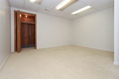 an empty room with white walls and ceiling lights on either side of the door,