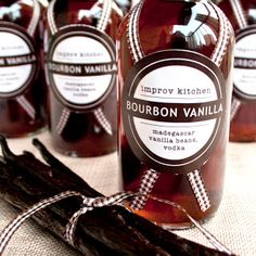 several bottles of bourbon vanilla sit on a table next to an old stick of cinnamon