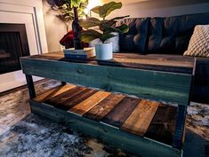 a coffee table made out of pallet wood with a plant on top and a vase in the middle