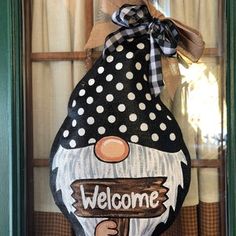 a welcome sign hanging from the side of a door