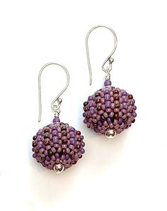 Beaded Earrings - Small glass beads in luxe orchid hues are hand woven one at a time around lightweight acrylic orbs. Sterling silver accent beads add extra polish. Comfortable sterling silver ear wires complete the look. Artisan Czech Glass Beaded Round Earrings, Artisan Czech Glass Beaded Earrings, Artisan Czech Glass Round Bead Earrings, Artisan Czech Glass Round Beaded Earrings, Purple Artisan Earrings With Ear Wire, Artisan Purple Earrings With Ear Wire, Artisan Purple Drop Earrings, Elegant Handwoven Round Beaded Earrings, Handmade Round Czech Glass Beaded Earrings