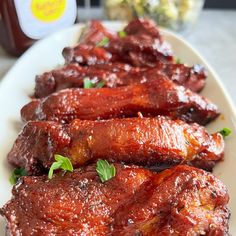 some meat is on a white plate with ketchup and mustard in the background