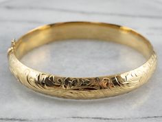 "Stunning! The details on this vintage 18 karat gold bangle are simply gorgeous! Intricate botanical designs are engraved in warm yellow gold, covering the entire bracelet. Beautiful on its own or layered with other bracelets this piece is perfect for day or evening wear. Metal: 18K Yellow Gold Width: 11.1 mm Inside Circumference: 7 Inches Marks: \"GERMANY 18KO \" Stamped To view a video of this piece check out the link below: https://vimeo.com/530900365 SKU #: JL4WMETT Each piece has been ident Luxury Gold Bracelets With Engraving Option, Luxury Engraved Classic Braided Bracelets, Affordable Engraved Bangle Bracelets, Luxury Handmade Round Gold Bracelet, Luxury Engraved Brass Bracelets, Luxury Brass Bangle Gift, Luxury Brass Engraved Bracelets, Luxury Hand-strung Gold Bracelet Gift, Luxury Engraved Spiritual Bangle