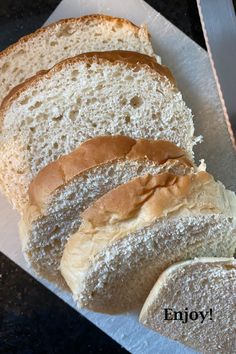 two loaves of bread sitting on top of a white paper towel with the words enjoy