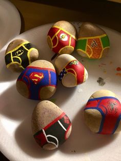 several painted rocks sitting on top of a white plate