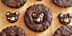 chocolate cookies with teddy bears in the middle on a wooden board, ready to be eaten