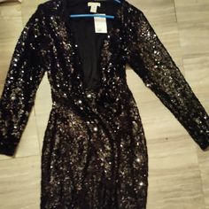 Black H&M Sequins Knee Length/ Midi Dress. Left Side Tie Closure On Dress Brand New With Tags. It's Yours H&m V-neck Mini Dress For Party, Fitted H&m Dresses With Sequins, H&m Sequin Dresses For Party Season, H&m Long Sleeve Party Dress, Fitted Sequin Dresses From H&m, H&m Knee-length Evening Dresses, H&m Dresses For Party Season, H&m Dresses For Night Out Party Season, H&m Sequined Dresses For Night Out