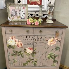 an old dresser with flowers painted on the front and side panels, along with other items