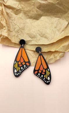 These beautiful Butterfly Wings Drop Earrings are the perfect addition to any outfit.  Handcrafted with sustainably sourced wood and finished with a carefully burnished surface, these earrings feature a delicate engraved butterfly design.  Lightweight and comfortable for all-day wear, these earrings will be sure to make a statement.  Upgrade your wardrobe with these unique wooden earrings and you'll surely feel special! The earring posts are made of hypoallergenic metal, and are nickel and lead Earrings Painting, Wooden Earrings Handmade, Butterfly Dangle Earrings, Wood Jewelery, Witch Earrings, Earrings Butterfly, Handmade Clay Jewelry, Boho Jewellery, Wood Designs