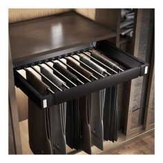 an open drawer in a cabinet filled with folded black shirts and pants on hangers