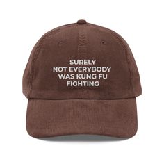 Surely Not Everybody Was Kung Fu Fighting Hat, Funny Embroidered Quote Hat, Funny Gift Vintage Corduroy Cap Step up your style with an embroidered old-school cap. It's crafted from 100% cotton corduroy that's soft to the touch and comfy to wear. It features an adjustable strap with a gold-colored buckle for a great fit and a visor to protect you from the sun and wind. Complete your look with this embroidered corduroy cap and rock a cool vibe all day long. * 100% cotton corduroy * Unstructured, 6-panel, low-profile * Cotton twill sweatband and taping * 6 embroidered eyelets * Adjustable strap with a gold-colored metal buckle * Head circumference: 20″-22″ (50.8 cm-56 cm) Brown Dad Hat With Letter Print, Brown Dad Cap With Letter Print, Winter Cotton Dad Hat With Letter Print, Winter Cotton Hat With Letter Embroidery, Cheap Funny Cap Style Hat, Brown Cotton Baseball Cap With Letter Print, Brown Embroidered Baseball Cap With Curved Brim, Retro Corduroy Hat For Streetwear, Brown Embroidered Curved Brim Baseball Cap