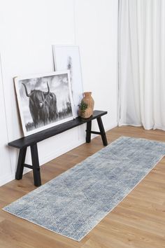 a black and white photo sitting on top of a wooden floor next to a bench