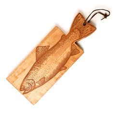 a wooden cutting board with a fish carved on the front and sides, hanging from a hook