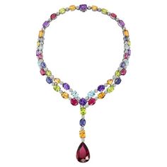 Crafted by master artisans with unparalleled skill and attention to detail, this necklace is meticulously arranged to create a harmonious symphony of color and light, further accentuated by the delicate sparkle of diamonds interspersed throughout the design. The dazzling array of peridot, blue topaz, citrine, iolite, and amethyst gemstones were each selected for their exceptional quality and vibrant brilliance all leading to the exceptional pear shape rubellite pendant. Indulge in the ultimate expression of luxury and sophistication with this extraordinary necklace, a timeless masterpiece that transcends trends and evokes a sense of timeless beauty and glamour. Dimensions: Interior Circumference: 13 1/2 inches Pendant Length: 3 inches Colorful Gemstone Necklace, Luxury Multicolor Necklace With Large Pendant, Color And Light, Necklace Design, Dream Jewelry, Drop Necklace, Amethyst Gemstone, Pear Shape, Gemstone Colors