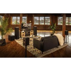 a living room filled with lots of furniture and large windows in the back drop off wall