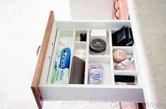 an open drawer with various beauty products and other personal care items in it on a counter top