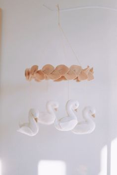 a white swan mobile hanging from the ceiling