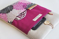 a pink and white ipad case with a cell phone on it's back pocket