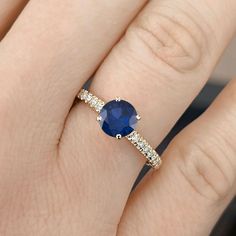 a woman's hand with a blue sapphire and diamond ring