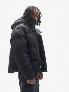 An ultra-warm solution to the cold in an easy oversized modern silhouette. Made from luxurious European materials in three colorways including a custom Italian mineral dye. Cloud-filled with responsibly sourced and traceable 700 fill power down. Features include an interior down-filled collar, adjustable hood and hem, and an eco-friendlier PFC free DWR for water-repellency. Made in the EU. Model is 6' 2", 32” Waist, 33” Chest and wears a size M. Size Shoulder IN Chest IN Sleeve IN S 43 52 37.25 Urban Oversized Nylon Puffer Jacket, Down Puffer Jacket For Streetwear In Techwear Style, Techwear Down Puffer Jacket For Streetwear, Functional Streetwear Down Outerwear, Functional Down Outerwear For Streetwear, Techwear Down Puffer Jacket For Cold Weather, Techwear Down Outerwear For Streetwear, Black Down Puffer Parka, Black Down Puffer Jacket For Cold Weather