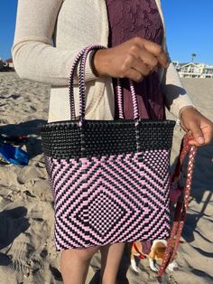 "This beautiful hand-woven, small tote is the latest creation of my business parter Cupertino. Handcrafted in Mexico. 9 1/2\"L x 9 1/2\"H x 5\"D; 16\" H with straps." Pink Woven Leather Tote Bag, Summer Pink Woven Leather Bags, Pink Tote Bag With Woven Leather, Pink Woven Leather Bags For Summer, Pink Woven Leather Tote Shoulder Bag, Pink Rectangular Shoulder Bag With Braided Handles, Pink Rectangular Woven Leather Shoulder Bag, Pink Rectangular Woven Leather Bag, Pink Straw Tote Bag With Adjustable Strap