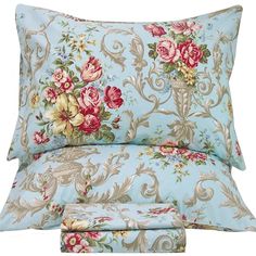 a bed with blue and pink flowers on the pillowcase, two pillows and one pillow case