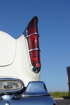 the tail light of a white motorcycle parked in a parking lot