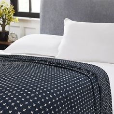 a bed with white pillows and blue bedspread