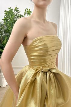 a woman in a gold dress posing for the camera