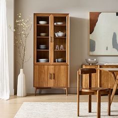 a dining room scene with focus on the china cabinet and table in the foreground