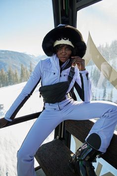 a woman in white is posing on a ski lift