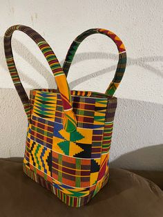 "This bag is made with kente cloth material.  Dimensions: 16\" W X 11\" H X 7\" D" Multicolor Fabric Shoulder Bag With Double Handle, Multicolor Double Handle Fabric Shoulder Bag, Multicolor Fabric Bag With Double Handle, Multicolor Fabric Bag With Handles, Fabric Multicolor Bag, Multicolor Fabric Tote Bag, Multicolor Fabric Shoulder Bag For Shopping, Yellow Fabric Rectangular Bag, Multicolor Bucket Shoulder Bag With Top Handle