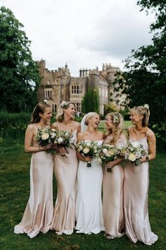 a group of women standing next to each other on top of a lush green field