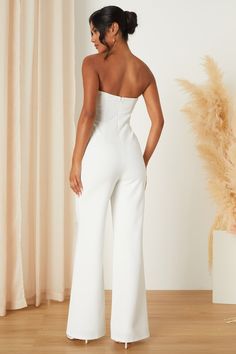 From the bridal shower to the rehearsal dinner, there are plenty of places to wear the Lulus Adoring Occasion White Strapless Wide-Leg Jumpsuit! All eyes are bound to stay on you thanks to this stunning jumpsuit that has a stretchy crepe knit composition that shapes a straight neckline and a strapless, princess-seamed bodice with sheer beige mesh panels at the sides (and hidden no-slip strips). The high, fitted waist tops trendy, wide pant legs that continue down to ankle-length hems. Hidden bac Backless Strapless Jumpsuit For Summer Formal, Summer Formal Backless Strapless Jumpsuit, Chic Strapless Backless Jumpsuit For Formal Occasions, Chic Strapless Backless Jumpsuit For Formal Events, Elegant Strapless Backless Jumpsuit For Formal Occasions, Chic Formal Strapless Backless Jumpsuit, Elegant White Strapless Jumpsuit For Evening, Elegant Fitted Jumpsuit For Wedding Guest, White Strapless Jumpsuit For Evening