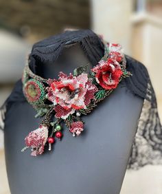 a black headband with red flowers and pearls