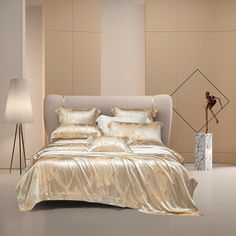 a bed with gold sheets and pillows in a room