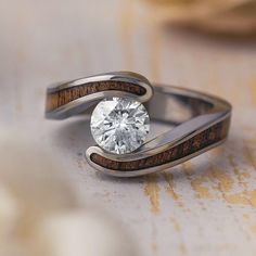 a close up of a ring with a diamond in the middle and two wooden bands around it