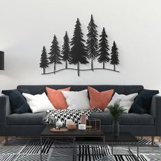 a living room with black and white furniture and trees on the wall behind it,