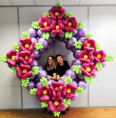 two women standing in front of a balloon wreath