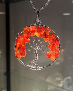 a tree of life pendant with orange glass beads