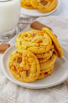 some cookies on a white plate next to a glass of milk