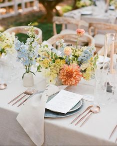 the table is set with flowers and silverware