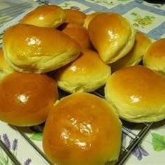 a pile of bread rolls sitting on top of a cooling rack