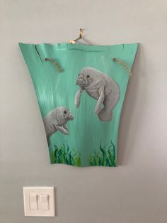 a wall hanging with an elephant and baby seal on it