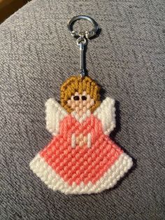 an embroidered angel keychain on a gray surface