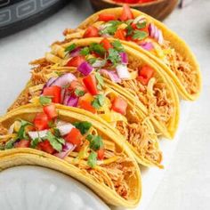 four tacos are lined up on a plate