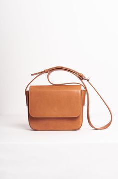 The Palmar is a leather crossbody bag that features a roomy compartment, a slim interior pocket, and one exterior pocket. It is handmade from vegetable-tanned leather and has a front flap closure with a magnetic snap. The leather strap can be adjusted to suit your preferred length, and the bag has a beige cotton lining. The exterior pocket allows you to keep your wallet and phone handy, yet safe at the same time. The sides and edges of the leather are delicately painted. This bag is joyfully man Classic Flap Bag With Detachable Strap For Daily Use, Classic Shoulder Flap Bag With Adjustable Strap, Classic Crossbody Shoulder Bag With Removable Pouch, Classic Satchel Shoulder Bag With Adjustable Strap, Rectangular Saddle Bag With Magnetic Closure For Daily Use, Classic Everyday Shoulder Flap Bag, Satchel Flap Bag With Magnetic Closure, Everyday Satchel Flap Bag With Magnetic Closure, Classic Flap Bag With Detachable Strap For Everyday Use